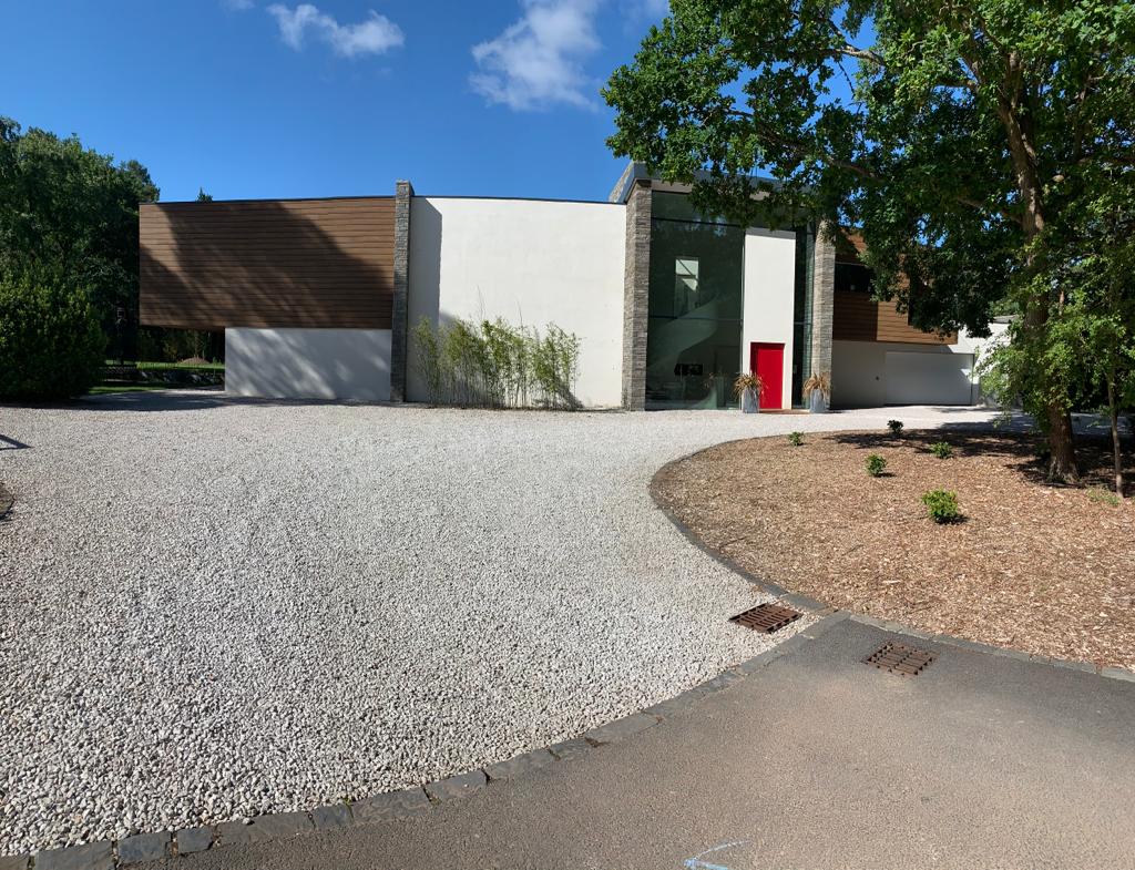 Curved render wall and the double-height glazed entrance